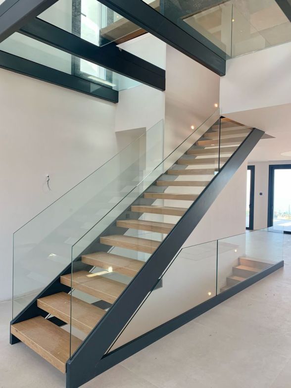 Villas Hacienda Paredes Málaga — detalle escalera interior volada con barandilla de vidrio